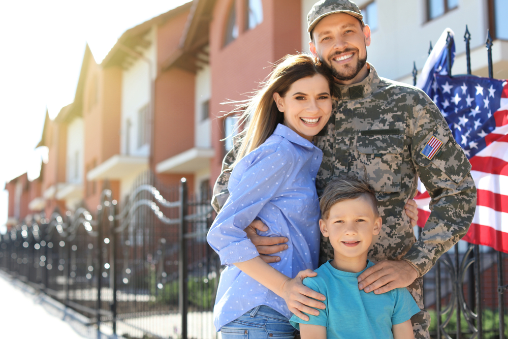 An American male soldier with his wife and son outside of a suburban street