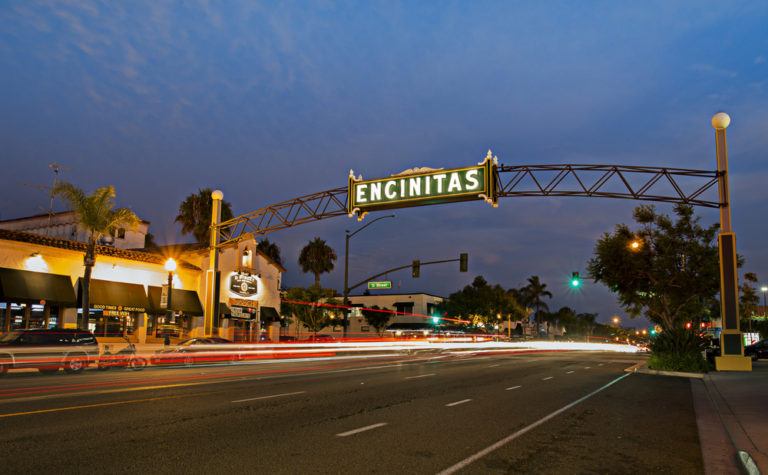 An overhead sign and a road leading into Encinitas, CA