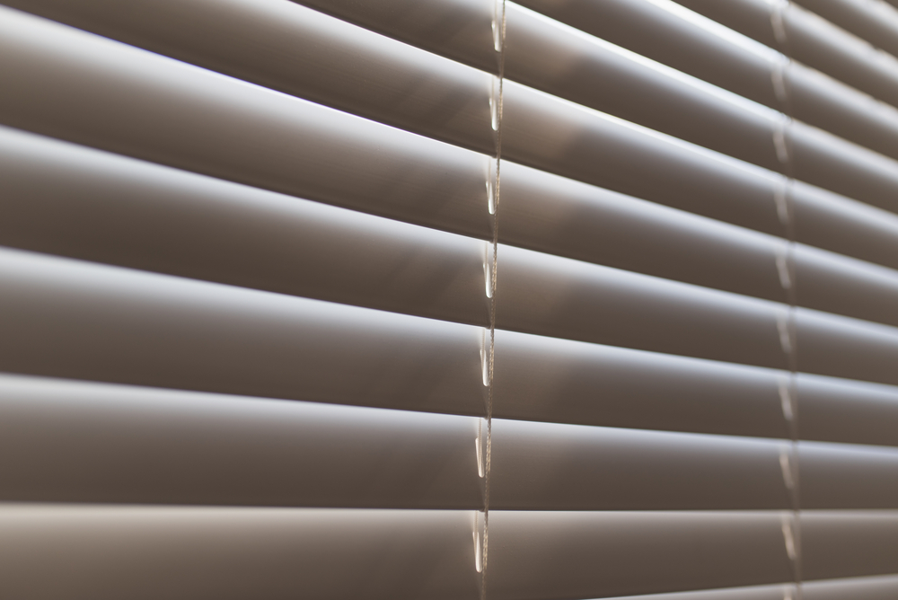 An angled closeup of shut blinds on a window